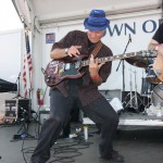 Robert Ross performing at the Riverhead Blues Festival in 2009 on the outdoor stage with Steve Holley (d) and Mark Dann (b) unseen.